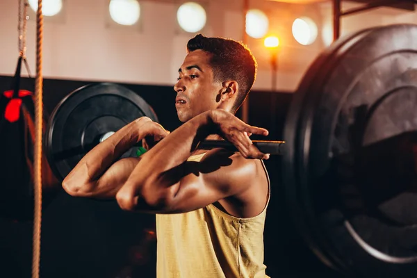 Homem musculoso no ginásio fazendo exercícios de peso pesado. Jovem fazendo levantamento de peso no health club — Fotografia de Stock