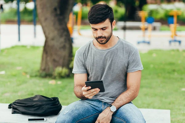 Jovem lendo e-book no parque — Fotografia de Stock