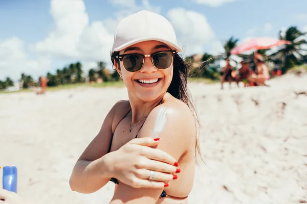 Protector solar, protector solar. Mulher colocando creme solar no ombro sorrindo belo dia de verão. Cuidado com a pele. Menina aplicando protetor solar — Fotografia de Stock