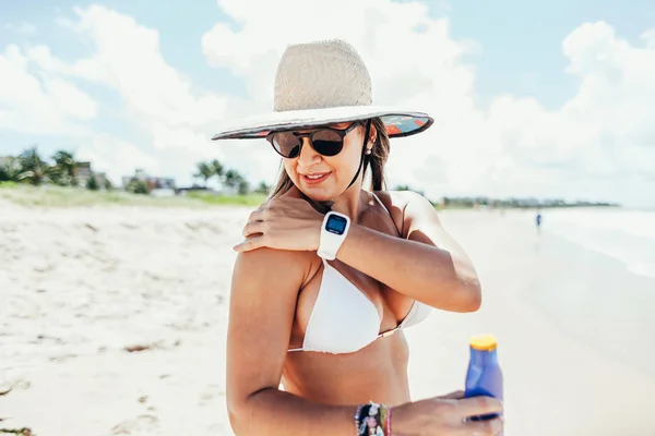 Zonnebrandcrème, sunblock. Vrouw zetten zonne-crème schouder glimlachend mooie zomerdag. Huidverzorging. Meisje toepassing van zonnebrandcrème — Stockfoto