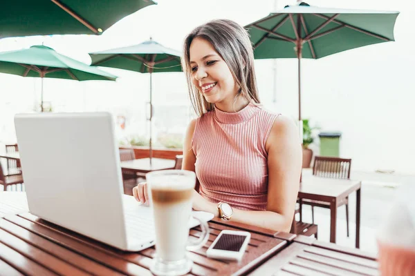 Wanita muda yang cantik menggunakan laptop di kafe — Stok Foto