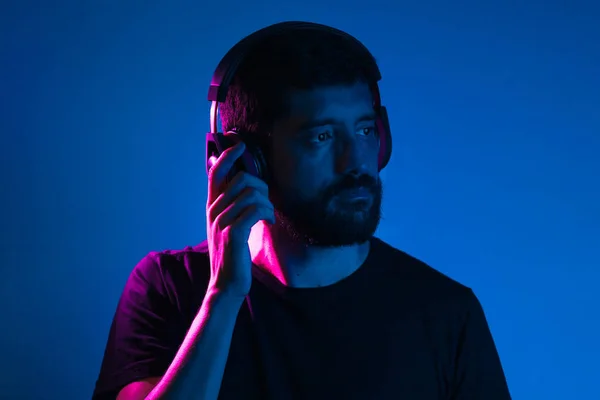 Neon light portrait of bearded man in headphones. Listening to music — Stock Photo, Image