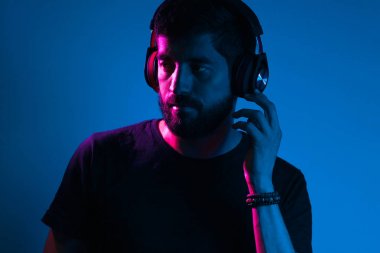 Kulaklıklı sakallı adamın Neon hafif portresi. M dinleme