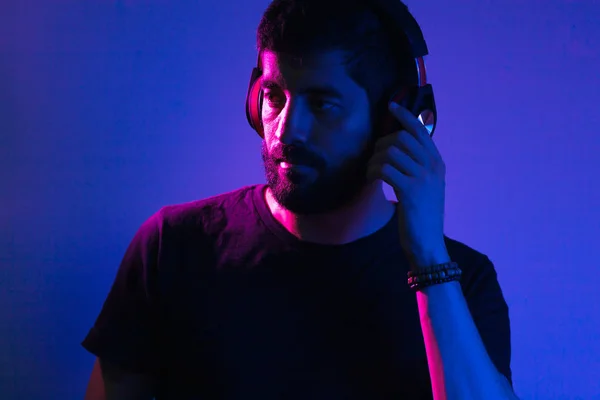 Неоновий світловий портрет бородатого чоловіка в навушниках. Прослуховування m — стокове фото