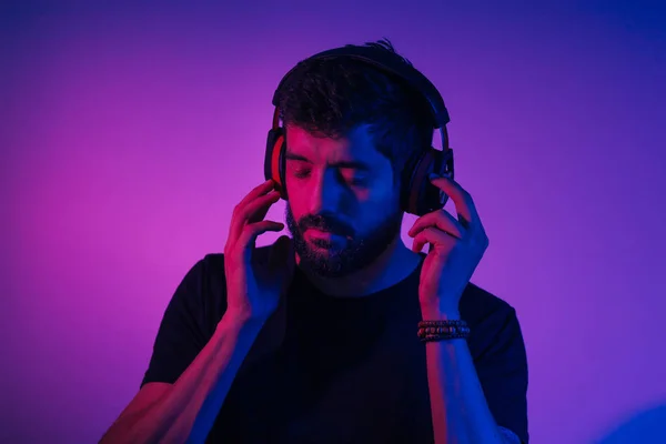 Neon light portrait of bearded man in headphones. Listening to m — Stock Photo, Image