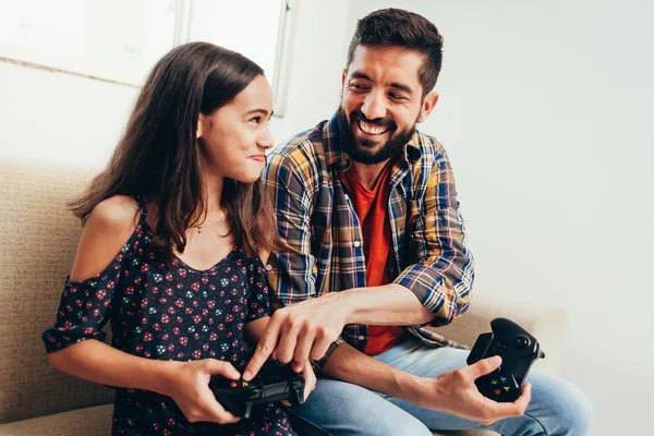 Sorridente padre e figlia giocare al videogioco a casa — Foto Stock