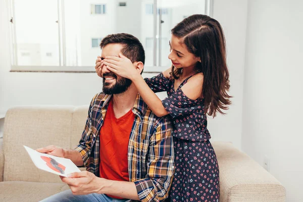 ¡Feliz día del padre! Hija felicitando a papá y dándole una tarjeta de felicitación. Papá y su hija sonriendo y abrazándose. Vacaciones familiares y unión — Foto de Stock