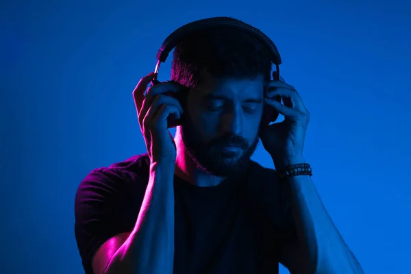 Neon light portrait of bearded man in headphones. Listening to music — Stock Photo, Image