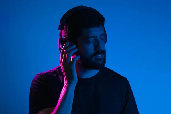 Kulaklıklı sakallı adamın Neon hafif portresi. M dinleme — Stok fotoğraf