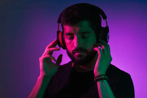 Neon light portrait of bearded man in headphones. Listening to music — Stock Photo, Image