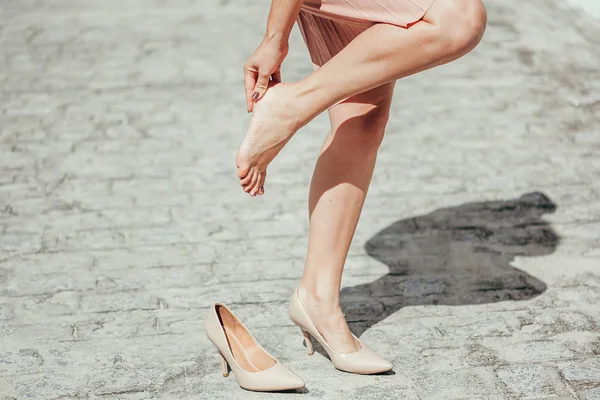 Woman suffering from leg pain outdoors because of uncomfortable — Stock Photo, Image