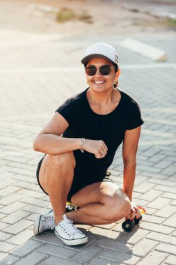 Şehirde kaykay ile güzel kadın portresi.