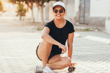 Şehirde kaykay ile güzel kadın portresi.