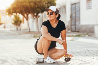 Şehirde kaykay ile güzel kadın portresi.
