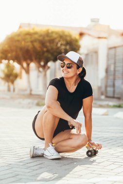 Şehirde kaykay ile güzel kadın portresi.