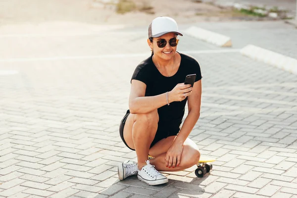 街のスケートボードを持つ美しい女性の肖像. — ストック写真