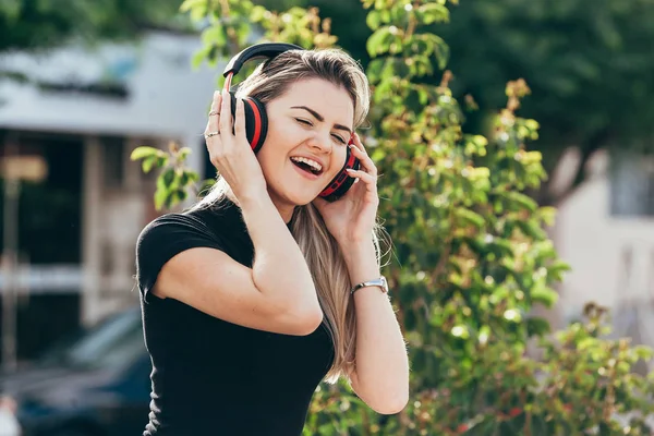 Güzel genç sarışın hipster kadın parkta müzik dinliyor