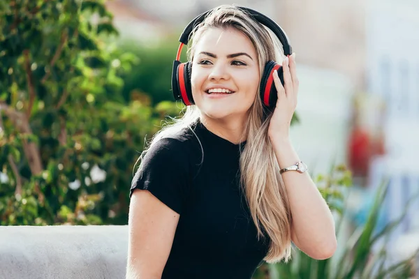 Güzel genç sarışın hipster kadın parkta müzik dinliyor