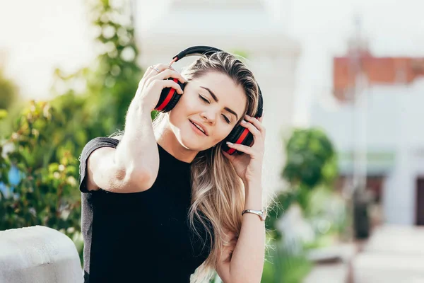 Bella giovane donna hipster bionda che ascolta musica nel parco — Foto Stock