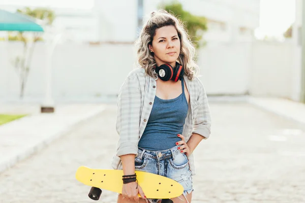 Ritratto di bella donna con skateboard in città . — Foto Stock