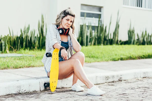 Ritratto di bella donna con skateboard in città . — Foto Stock