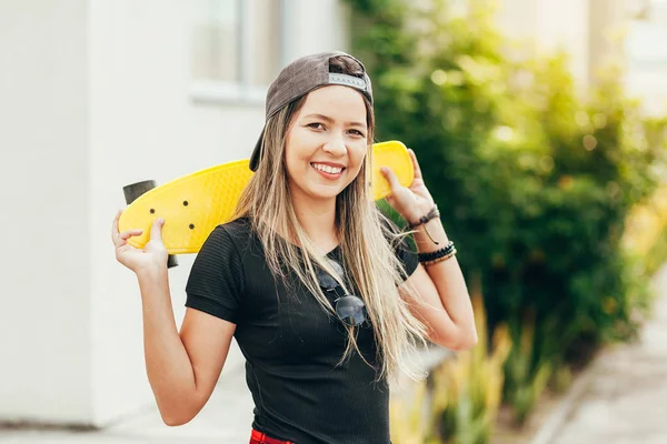 Portrét usmívajícího se mladé ženské skateboardista se svým skatekantem — Stock fotografie