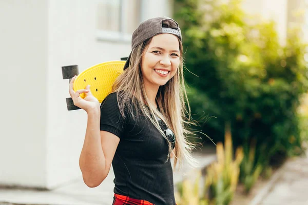 Retrato de una joven patinadora sonriente con su monopatín —  Fotos de Stock