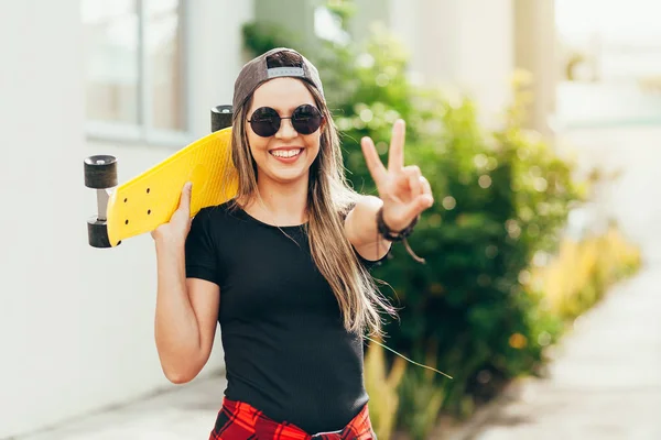 Retrato de una joven patinadora sonriente con su monopatín —  Fotos de Stock