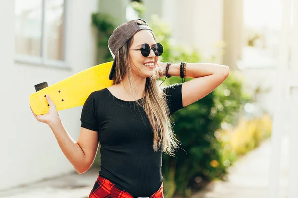Портрет улыбающейся юной скейтбордистки со своим скейтбордистом — стоковое фото