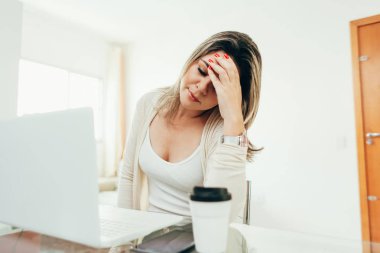 Endişeli kadın evde bir dizüstü bilgisayar üzerinde çalışıyor