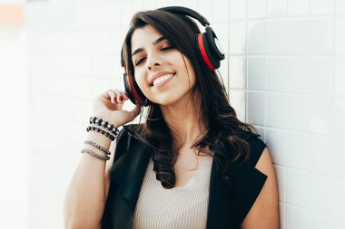 Açık havada müzik dinleyerek kulaklık kullanarak genç güzel kadın