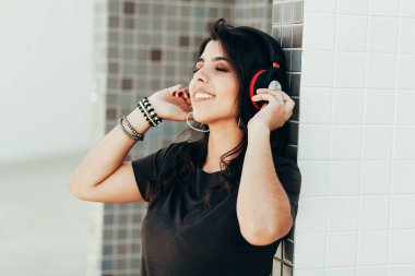 Açık havada müzik dinleyerek kulaklık kullanarak genç güzel kadın