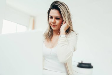 Evde dizüstü bilgisayarda çalışan güzel bir kadın.