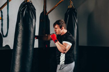 Spor salonunda kum torbası ile egzersiz Kas kickbox savaşçı