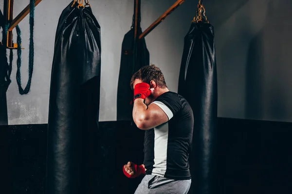 체육관에서 펀치 백으로 운동하는 근육 질의 킥박스 전투기 — 스톡 사진