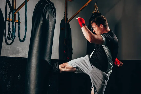 Spor salonunda kum torbası ile egzersiz Kas kickbox savaşçı
