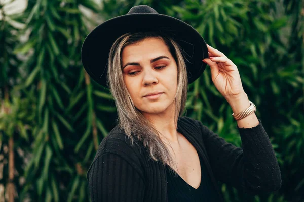 Portret van mooie vrouw die Fedora hoed buitenshuis draagt — Stockfoto