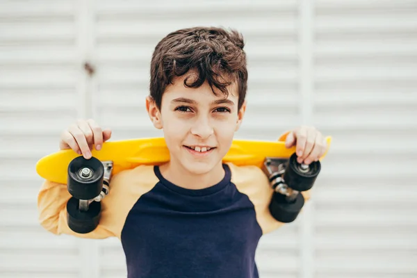 Portrait of 9 year old boy holding skateboard outdoors — Stock Photo, Image