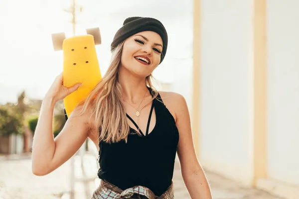 Портрет улыбающейся юной скейтбордистки со скейтбордом на открытом воздухе — стоковое фото