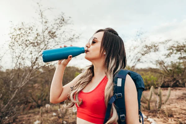 Caminante cansado bebe agua de una botella — Foto de Stock