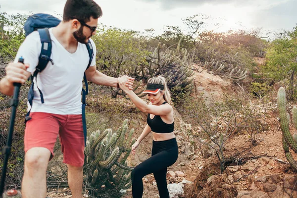 Caminhante do sexo masculino ajudando sua namorada subida no campo. Tu... — Fotografia de Stock