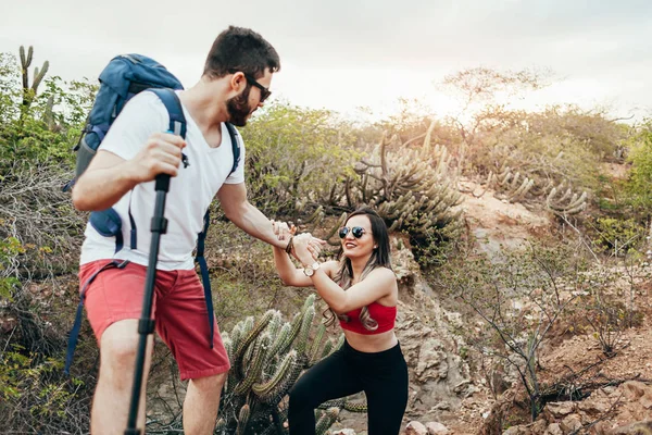 Caminhante do sexo masculino ajudando sua namorada subida no campo. Tu... — Fotografia de Stock