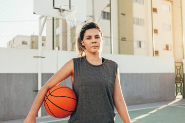 Genç bayan basketbolcu yerel bir sahada antrenman yapıyor.