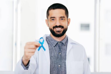 Prostat kanseri farkındalığı. Doktor, yaşayan ve hasta insanları desteklemek için açık mavi kurdele tutuyor. Erkekler Sağlık ve Dünya Kanser Günü Konsepti
