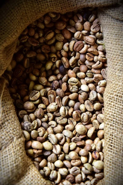 Unrefined coffee beans in a jute bag