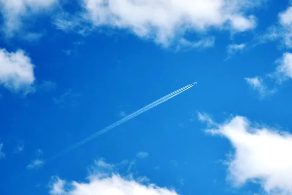 Jet duman ve derin mavi gökyüzü beyaz bulutlar