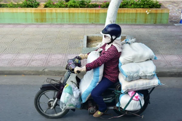Nha Trang, Vietnam, 12 Temmuz 2018: Kimliği belirsiz bir kadın sokakta aşırı yüklenmiş motosiklet sürücüleri