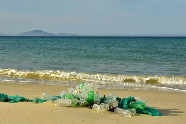 Self-made white plastic bottles buoy a tied to a rope confused network fishing fish on a wet sand background ocean design beach fishing village. Garbage thrown ashore by waves