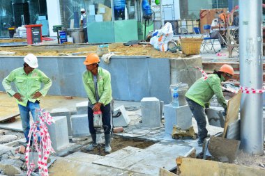 12 Temmuz 2018. Nha Trang. Vietnam. Otel Kompleksi İnşaatı Genel işçiler. Bir çekiç olarak çalışıyor. Trençkot yok eder