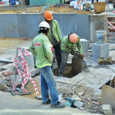 12 Temmuz 2018. Nha Trang. Vietnam. Otel Kompleksi İnşaatı Genel işçiler. Trençkot yok eder. Harekete geçiren ve kaldırım döşeme atar. Çöp toplama